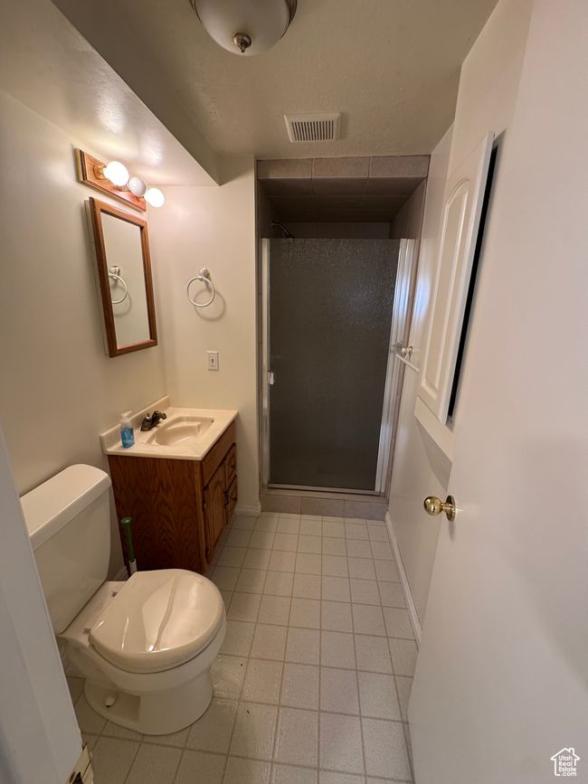 Bathroom with a stall shower, vanity, and tile patterned floors | Image 15