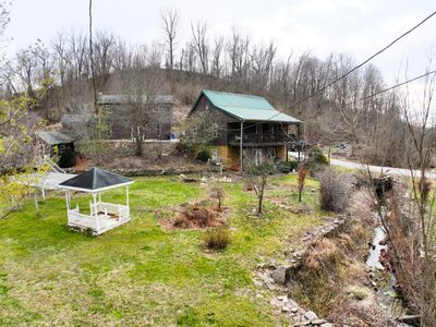 Creek in front of the house is lined with stacked rocks. They are used throughout the property. | Image 3