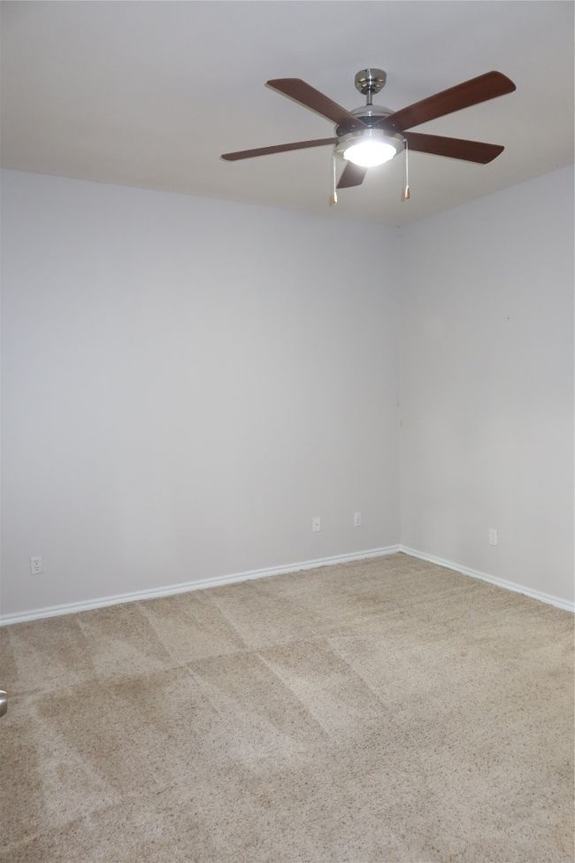 Carpeted empty room featuring a ceiling fan and baseboards | Image 14
