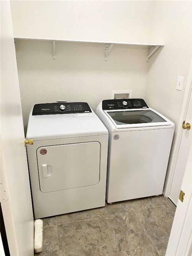Washroom featuring washing machine and dryer and light stone finish flooring | Image 19