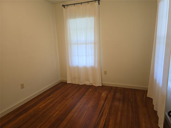 Empty room with dark wood-type flooring and baseboards | Image 11