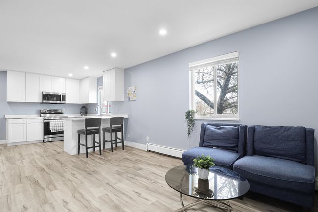 Living room with a baseboard radiator, baseboards, light wood-style floors, and recessed lighting | Image 6