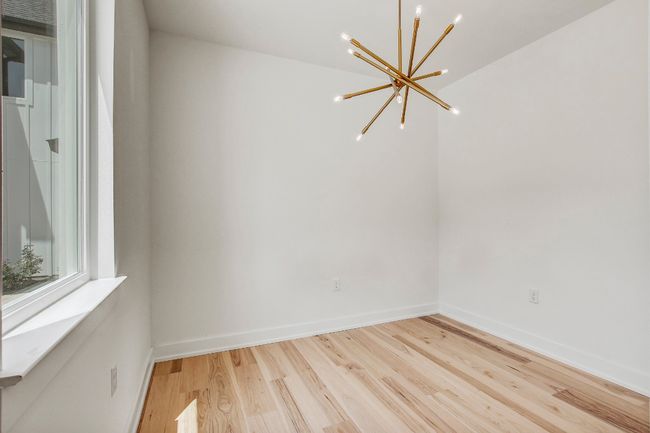 Unfurnished room featuring a chandelier, wood finished floors, and baseboards | Image 11