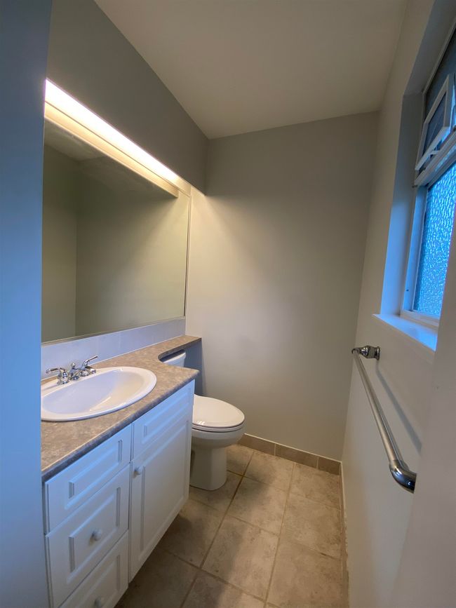 Half bath with vanity, toilet, baseboards, and tile patterned flooring | Image 12