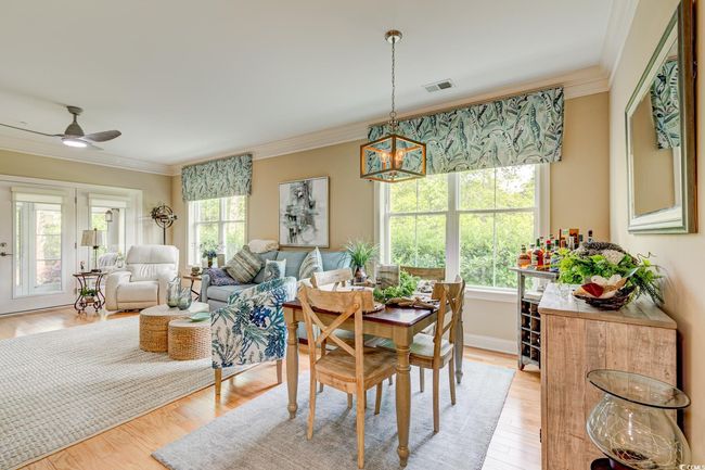 Dining space with light wood finished floors, ceiling fan, visible vents, and ornamental molding | Image 9