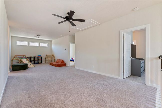 Game room featuring attic access, carpet flooring, baseboards, and a ceiling fan | Image 26