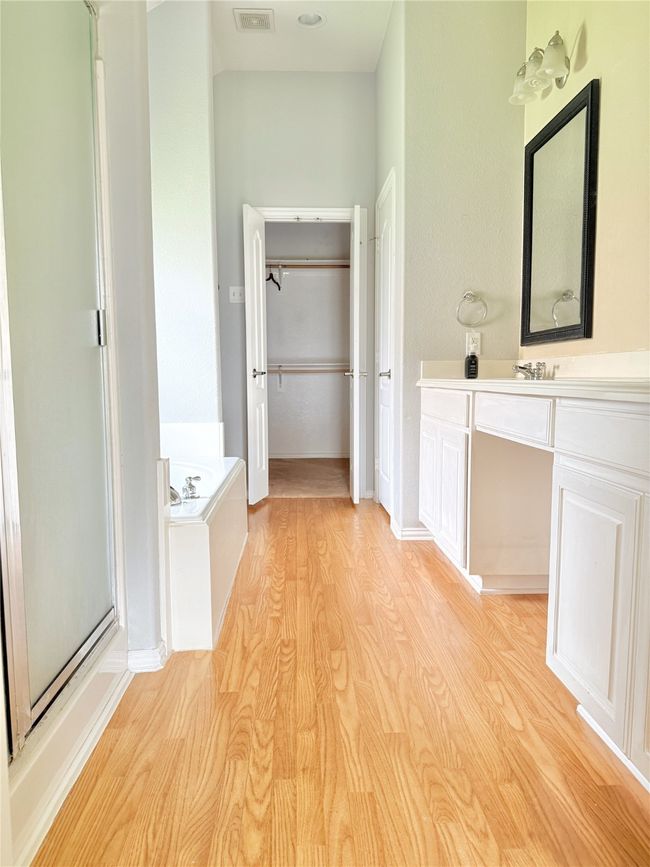 Full bathroom with a shower stall, vanity, wood finished floors, and a bath | Image 12