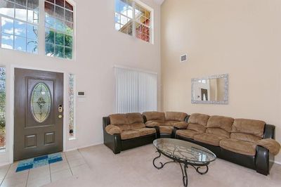 Living room featuring a high ceiling and tile patterned flooring | Image 2