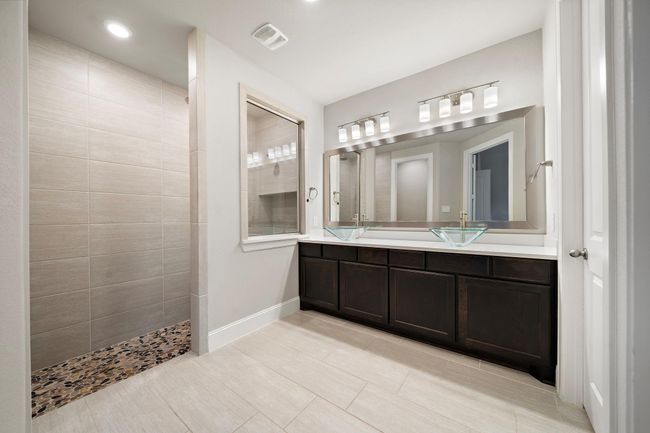 Upgraded primary bathroom featuring double vessel glass sinks and an oversized walk-in shower. | Image 11