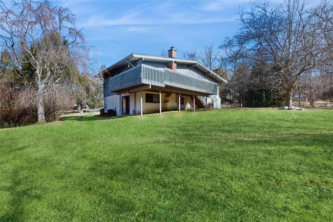 Rear view of property with a wooden deck, a chimney, and a yard | Image 31