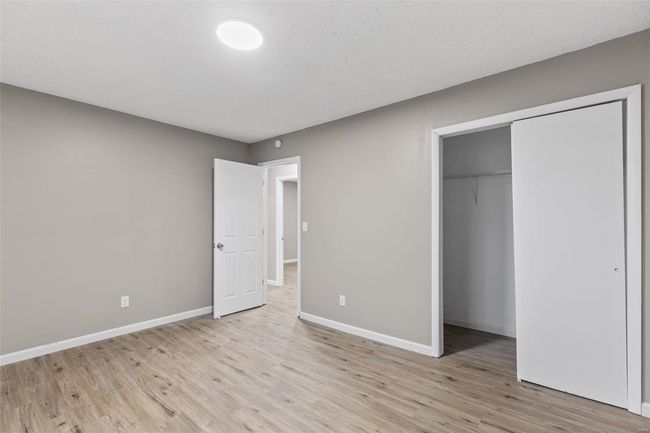 Unfurnished bedroom with baseboards, light wood-type flooring, and a closet | Image 19