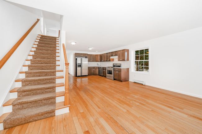 Stairs featuring baseboards, a baseboard heating unit, and hardwood / wood-style flooring | Image 11