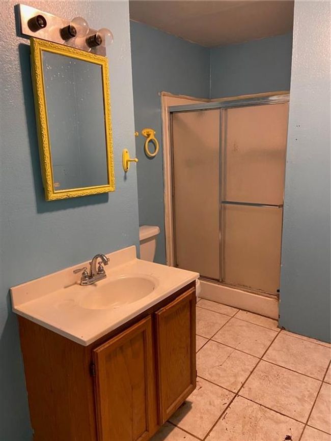 Bathroom featuring tile patterned floors, vanity, and a shower stall | Image 8