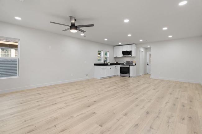 Unfurnished living room with light wood finished floors, recessed lighting, baseboards, and a ceiling fan | Image 4