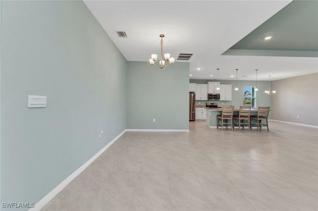 Unfurnished dining/living room featuring recessed lighting, a notable chandelier, baseboards, and visible vents | Image 18