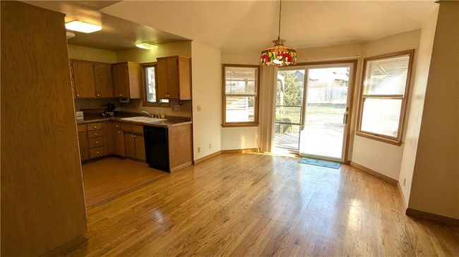 Kitchen with dishwasher, light hardwood / wood-style flooring, hanging light fixtures, and sink | Image 17