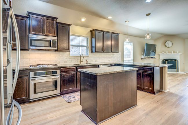 Kitchen with light wood finished floors, a sink, and stainless steel appliances | Image 12