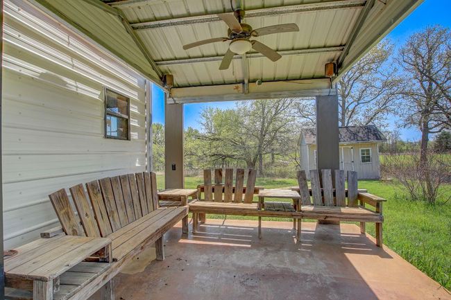 View of patio with a storage unit, an outdoor structure, and a ceiling fan | Image 19