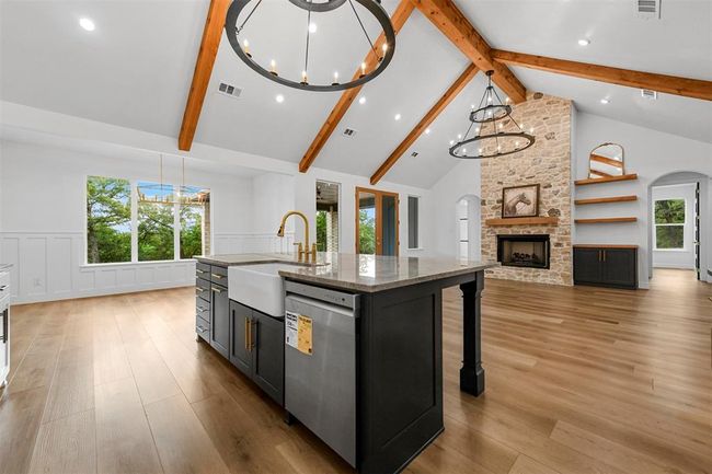 Kitchen featuring stainless steel dishwasher, sink, beamed ceiling, and a kitchen island with sink | Image 15