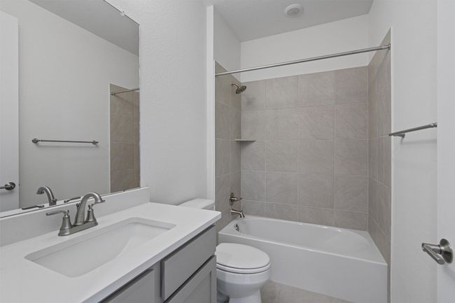 Second bath with tub, quartz vanity and tile flooring. | Image 19