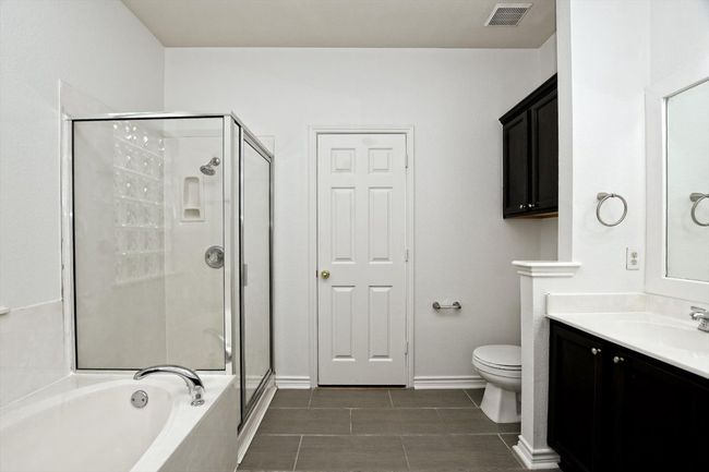 Bathroom with a shower stall, vanity, a bath, and tile patterned floors | Image 14