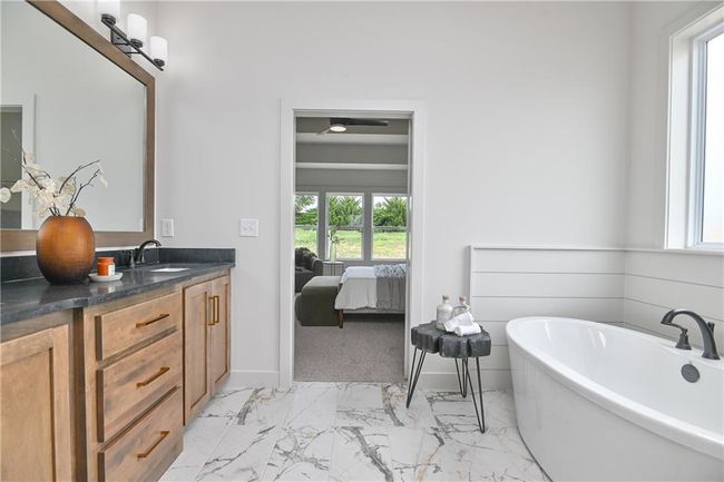 Bathroom with vanity, tile patterned flooring, and a tub | Image 25