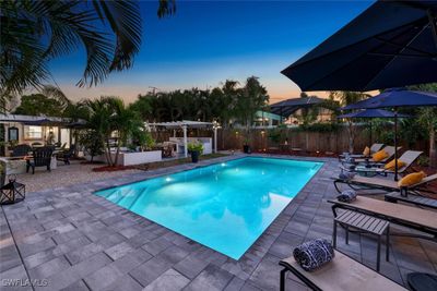 Pool at dusk featuring a patio area | Image 1