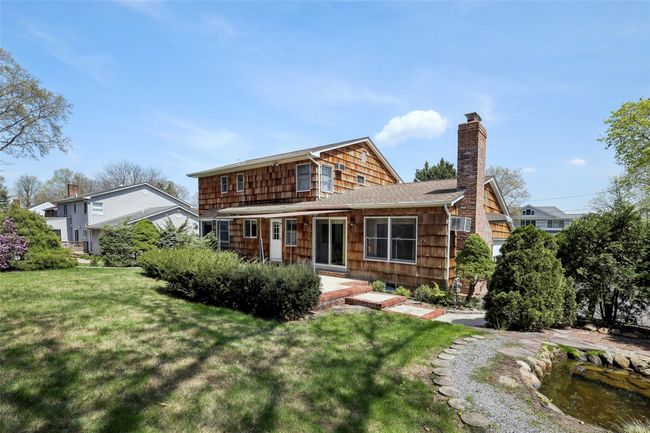 View of front facade with a chimney, a front yard, and a shingled roof | Image 39