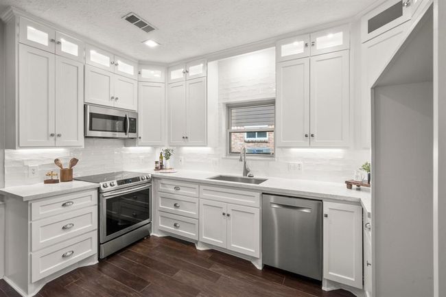 Thoughtful features like large pot and pan drawers, a convenient Lazy Susan, a built-in garbage pull-out, and under-cabinet sliders make this kitchen as functional as it is beautiful. | Image 8