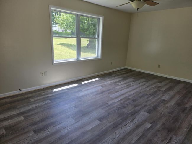 Empty room with a ceiling fan and dark wood finished floors | Image 15