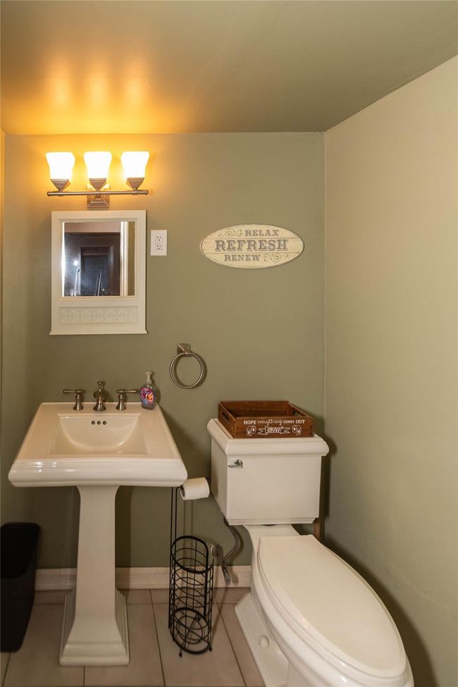 Half bath with toilet, tile patterned flooring, and baseboards | Image 20