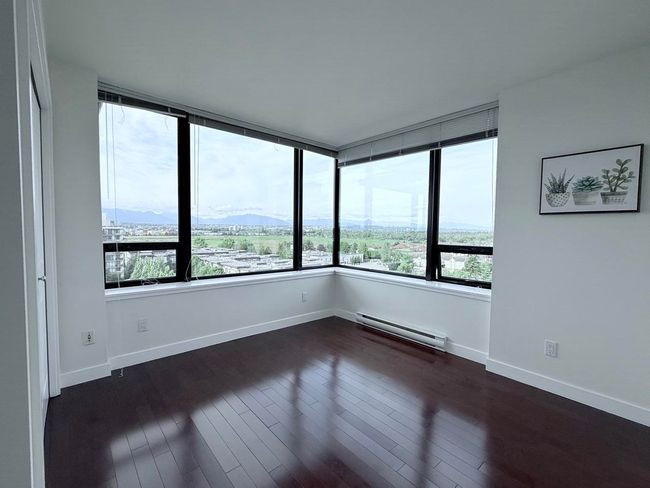 Spare room featuring a baseboard radiator, a mountain view, and dark wood-style flooring | Image 22