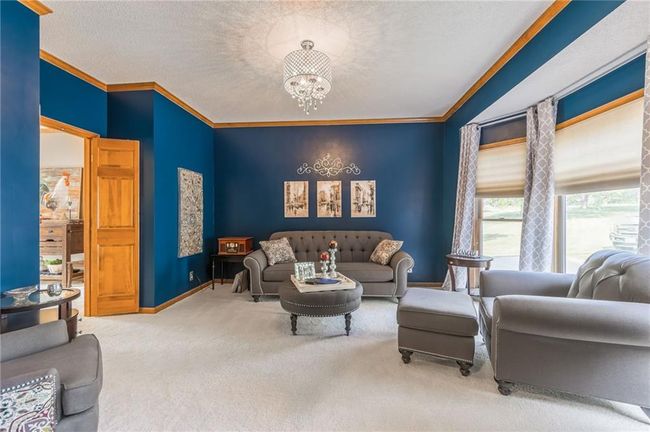 Living area featuring baseboards, ornamental molding, a chandelier, and carpet floors | Image 20