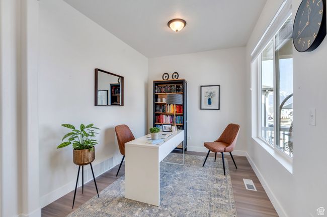 Home office featuring wood finished floors, baseboards, and visible vents | Image 21