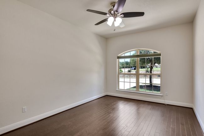 Spare room featuring dark wood-type flooring and ceiling fan | Image 28