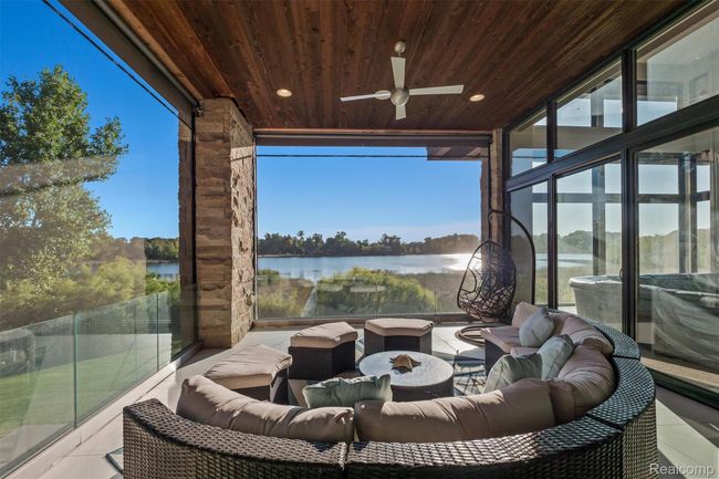 View of patio with a ceiling fan, a water view, an outdoor hangout area, and a sunroom | Image 16