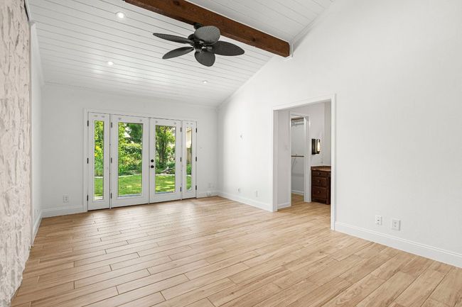 Empty room featuring ceiling fan, light wood finished floors, and wood ceiling | Image 16