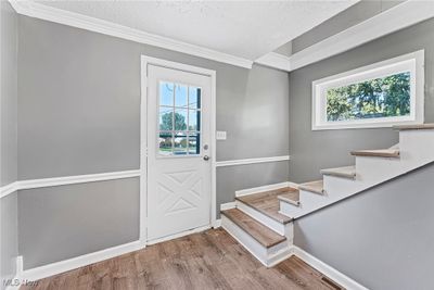 Entrance foyer featuring a textured ceiling, wood-type flooring, and crown molding | Image 3