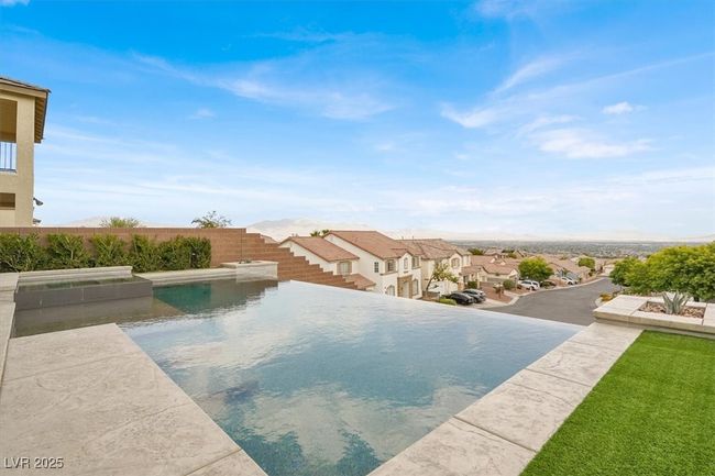 View of pool featuring a residential view and a pool with connected hot tub | Image 59
