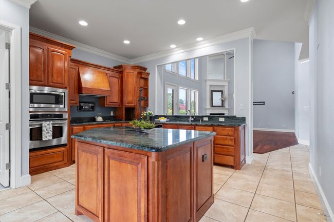 Warm and inviting kitchen featuring rich wood built-in cabinets that offer timeless style and ample storage for everyday essentials. | Image 7