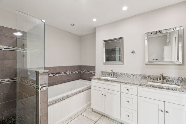 Full bathroom featuring double vanity, a bath, a stall shower, tile patterned flooring, and recessed lighting | Image 11