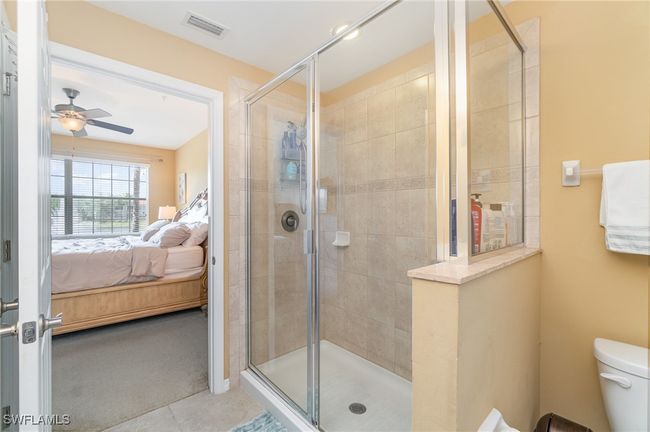 Full bathroom with connected bathroom, a stall shower, ceiling fan, and toilet | Image 10
