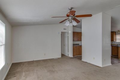 Unfurnished living room featuring lofted ceiling, ceiling fan, and carpet | Image 3