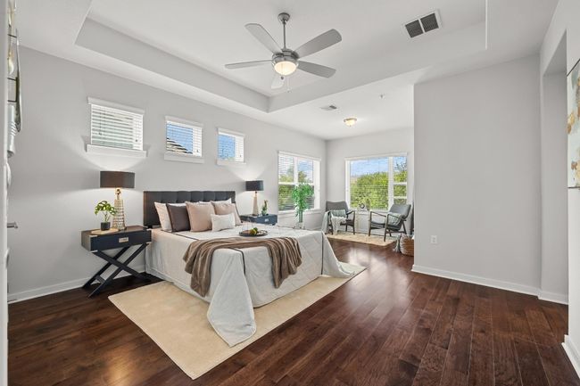 The spacious primary bedroom offers a peaceful retreat with corner windows that flood the room with natural light and offer views of the surrounding neighborhood | Image 22