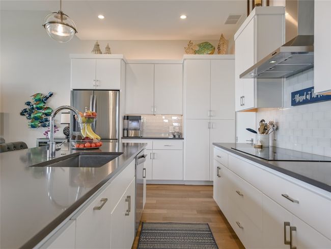 Deep pot drawers are conveniently located under the cooktop, while a pull-out trash drawer is located in the island. | Image 10