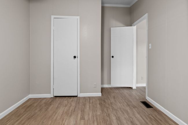 Unfurnished bedroom featuring wood finished floors and crown molding | Image 30