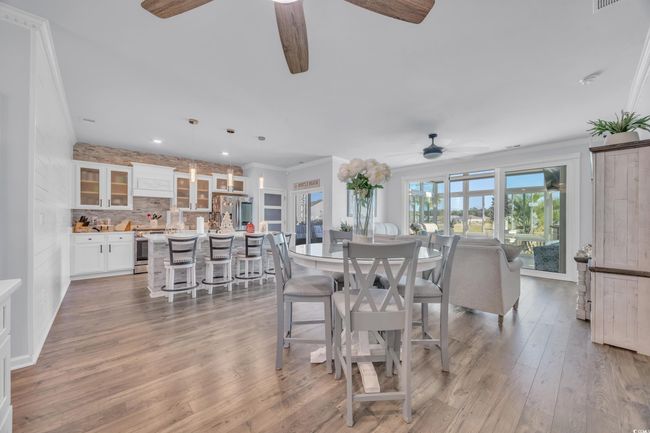 Dining room featuring ceiling fan, light wood-type flooring, ornamental molding, and recessed lighting | Image 11