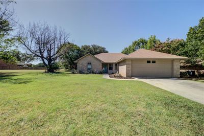 Ranch-style home with a garage and a front lawn | Image 3