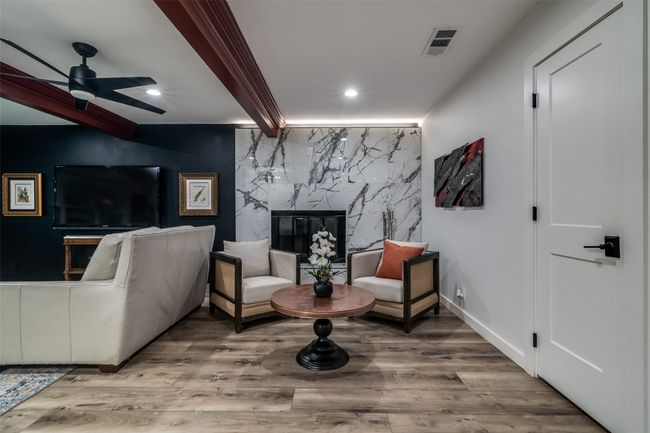 Living area with a ceiling fan, wood finished floors, recessed lighting, and a high end fireplace | Image 8