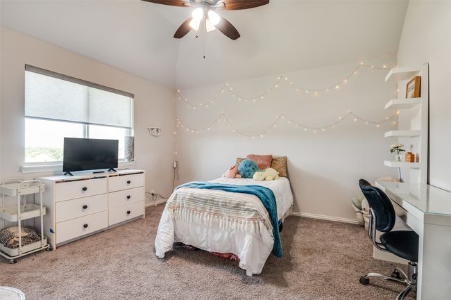 Bedroom featuring light carpet, lofted ceiling, a desk, and ceiling fan | Image 22